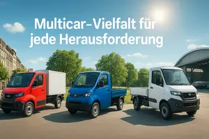 Drei elektrische Arbeitsfahrzeuge in Blau, Rot und Weiß stehen nebeneinander auf einer Straße