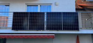 Solarkraftwerk am Balkon mit zwei Solarmodulen zur Stromerzeugung an einer Hausfassade montiert.