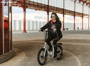 Frau fährt auf einem E-Bike der Marke UrbanBiker in einem Gebäude