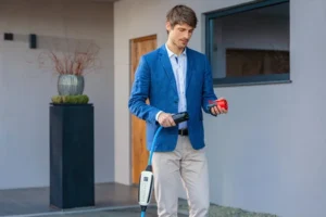 Mann mit mobilem Ladegerät für Elektroautos zeigt innovative Lade- & Energielösungen für Zuhause