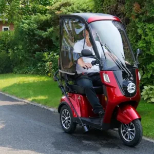 Ein Mann fährt mit einem Elektromobil mit Wetterschutz in die Natur – komfortabel, sicher und nachhaltig unterwegs mit E-Mobilität & Fahrzeuge.