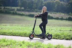 Mädchen fährt auf einem E-Roller über die Wiese – umweltfreundliche Elektromobilität erleben“