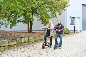 Zwei Jugendliche fahren mit E-Rollern durch die Stadt – Marken & Produkte der B.W. Vertrieb GmbH für urbane Elektromobilität.
