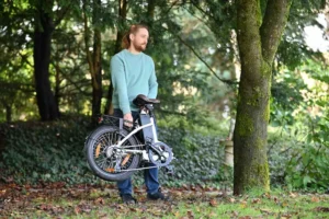 Mann zeigt ein zusammengeklapptes NCM E-Bike – ideal für einfache Aufbewahrung, Mobilität in der Stadt und flexible Nutzung unterwegs
