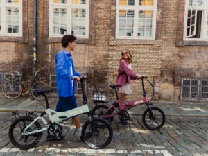 MATE E-Bikes – Junge und Mädchen gehen mit zwei E-Bikes auf der Straße