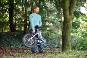 Mann zeigt ein zusammengeklapptes NCM E-Bike – ideal für einfache Aufbewahrung, Mobilität in der Stadt und flexible Nutzung unterwegs