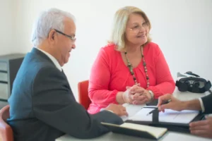 Mann und Frau unterschreiben ein Angebot für ein Rolektro Elektromobil mit Hilfsmittelnummer – Start der Kostenübernahme durch Krankenkasse und Beratung durch B.W. Vertrieb