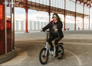 Frau fährt auf einem E-Bike der Marke UrbanBiker in einem Gebäude